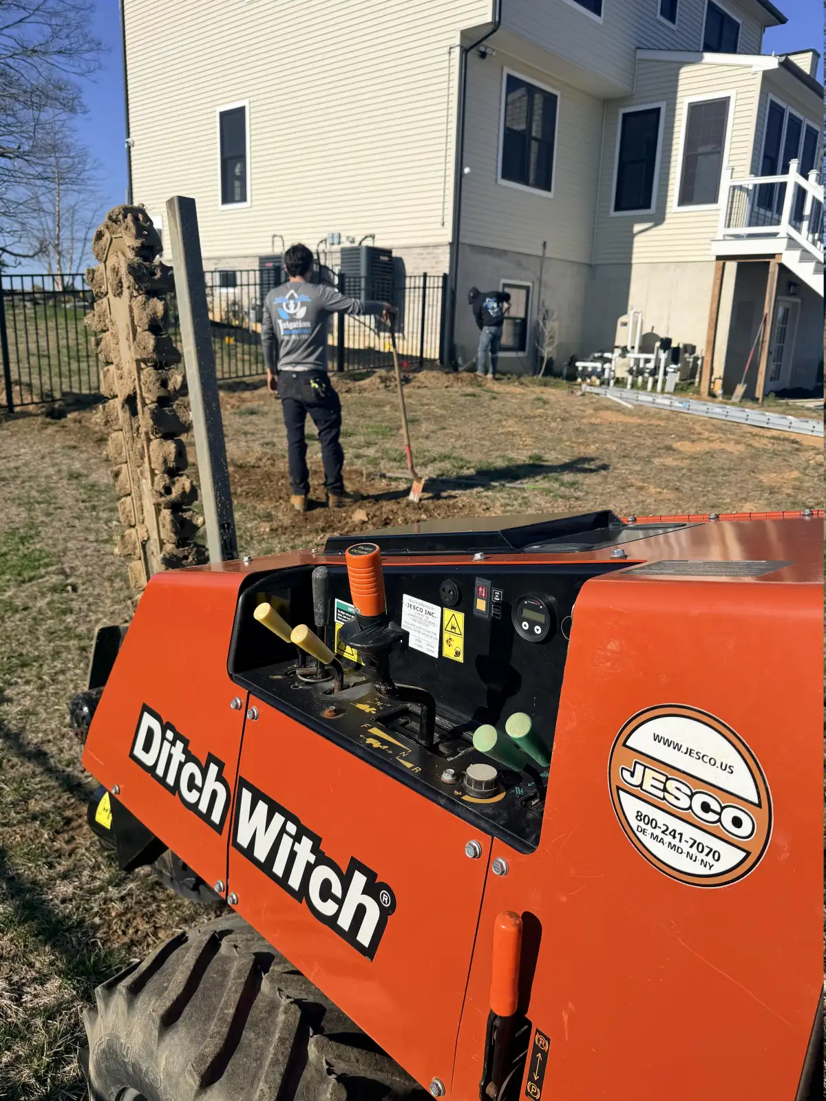 Ditch Witch trencher cutting irrigation lines in backyard