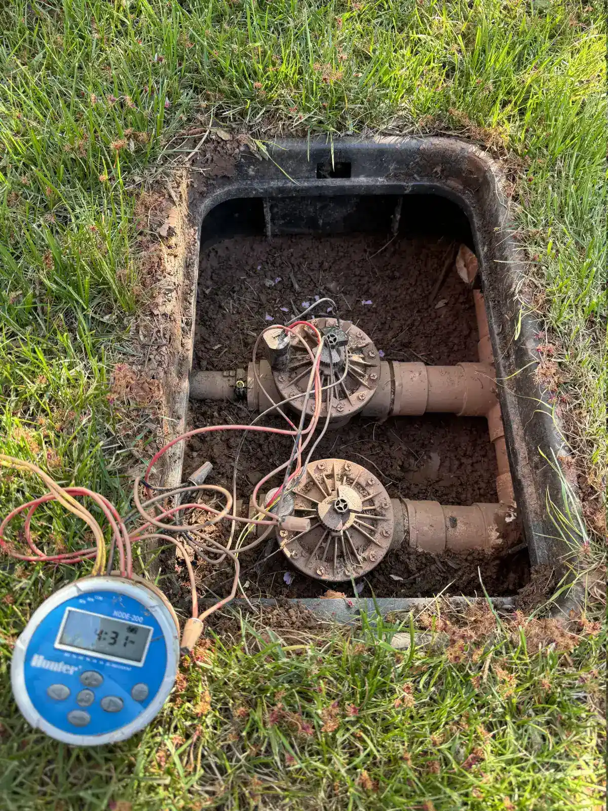 Hunter node valve box being inspected during irrigation maintenance