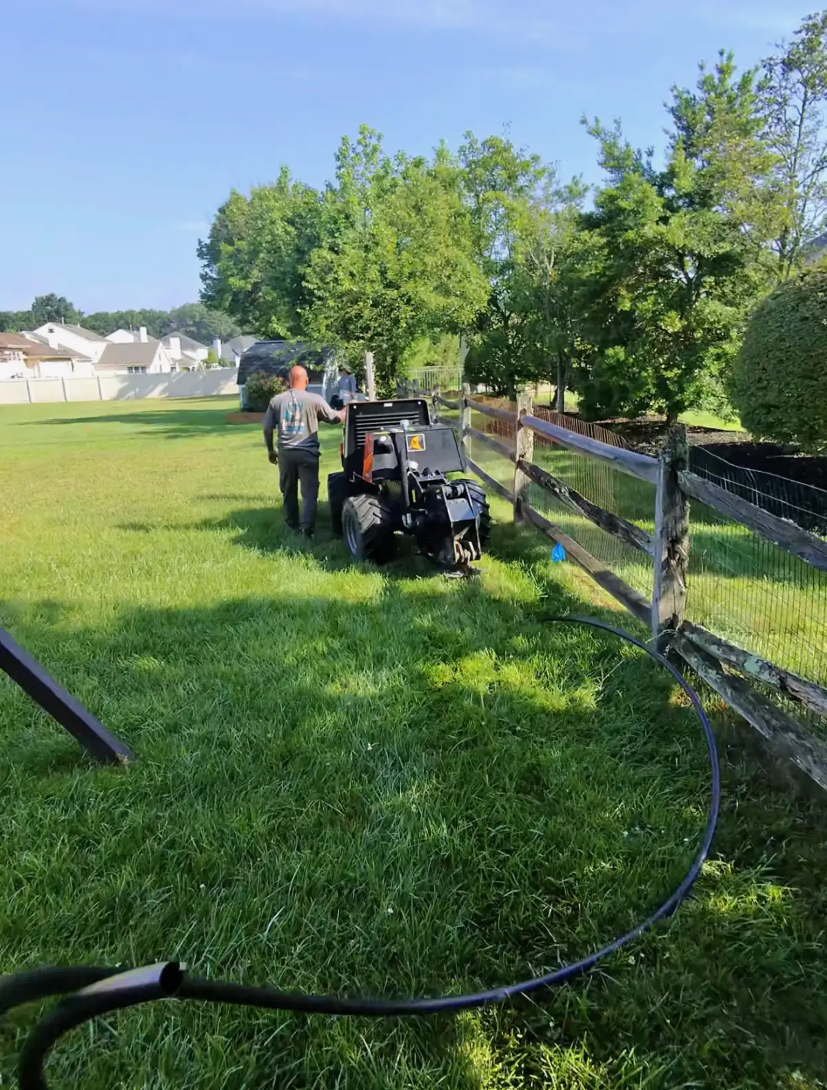 Irrigation crew operating vibratory plow for pipe installation